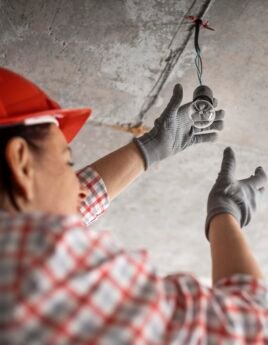 low-angle-female-construction-worker-with-light-bulb