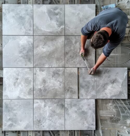 A man working on a tile floor, suitable for construction projects.